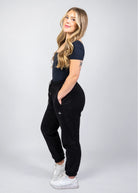 Woman wearing Nexarina Willow Sweatpants in Midnight Black from a side angle