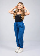 Women's Willow Sweatpants in Dusty Blue shown from the front with drawstring waist, tapered leg and Nexarina logo.