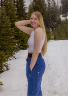 Side view of the women's Willow Sweatpants in Dusty Blue worn outdoors in the snow, showing the fit through the hip and leg.